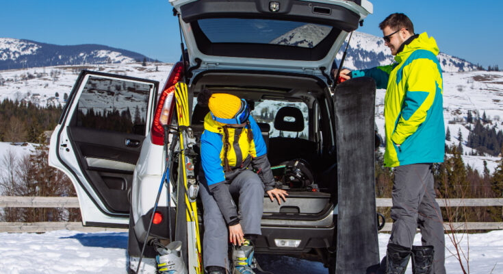 man-woman-dressing-into-ski-equipment-near-suv-car-mountains-background